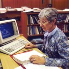 A photograph from the Cancer Visuals Online project of a librarian at the National Library of Medicine using a computer to access the Physicians Data Query (PDQ), used as an emblematic image for EDRN's common data elements (CDEs).